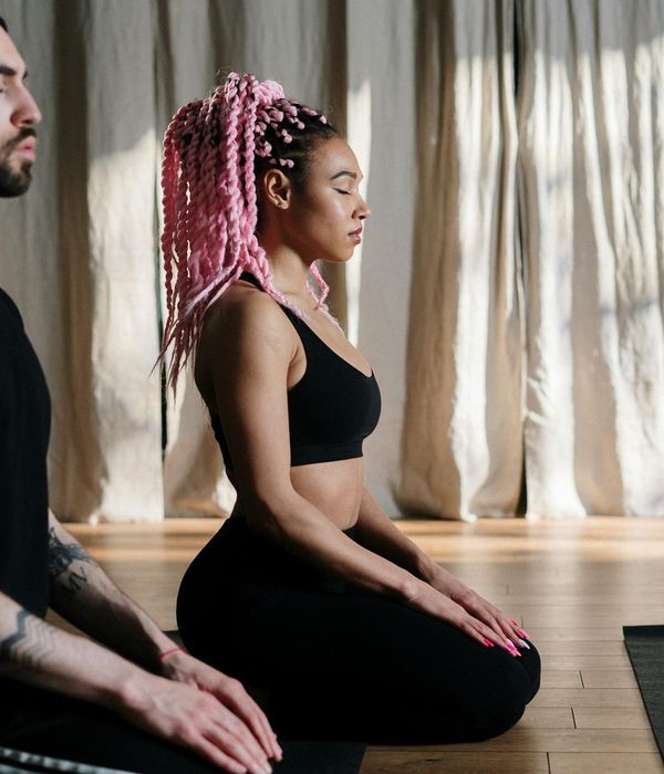 Smiling woman relaxing on a yoga mat after a practice session.